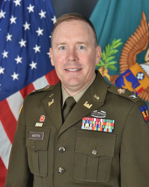 Charles B Martin Jr is wearing his Virginia National Guard uniform in front of the American flag and the Commonwealth of Virginia flag.