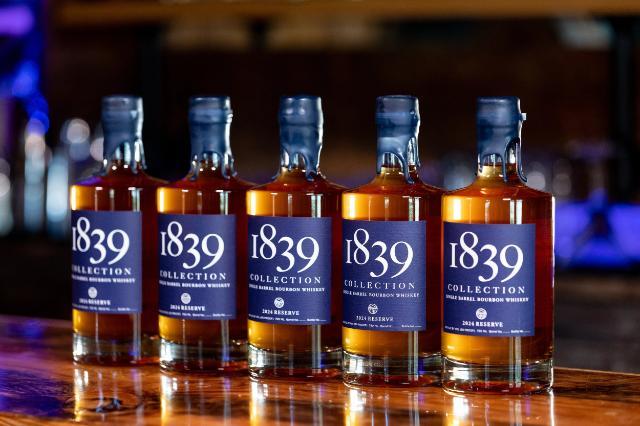 Bottles of 1839 Collection 2024 Reserve bourbon lined up on a bar