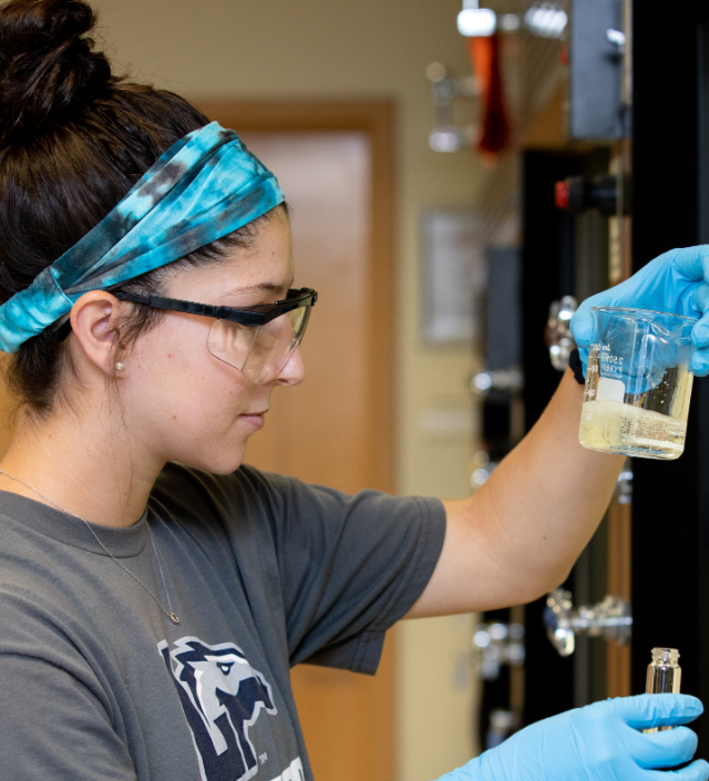 Student looks at beaker in Science Lab