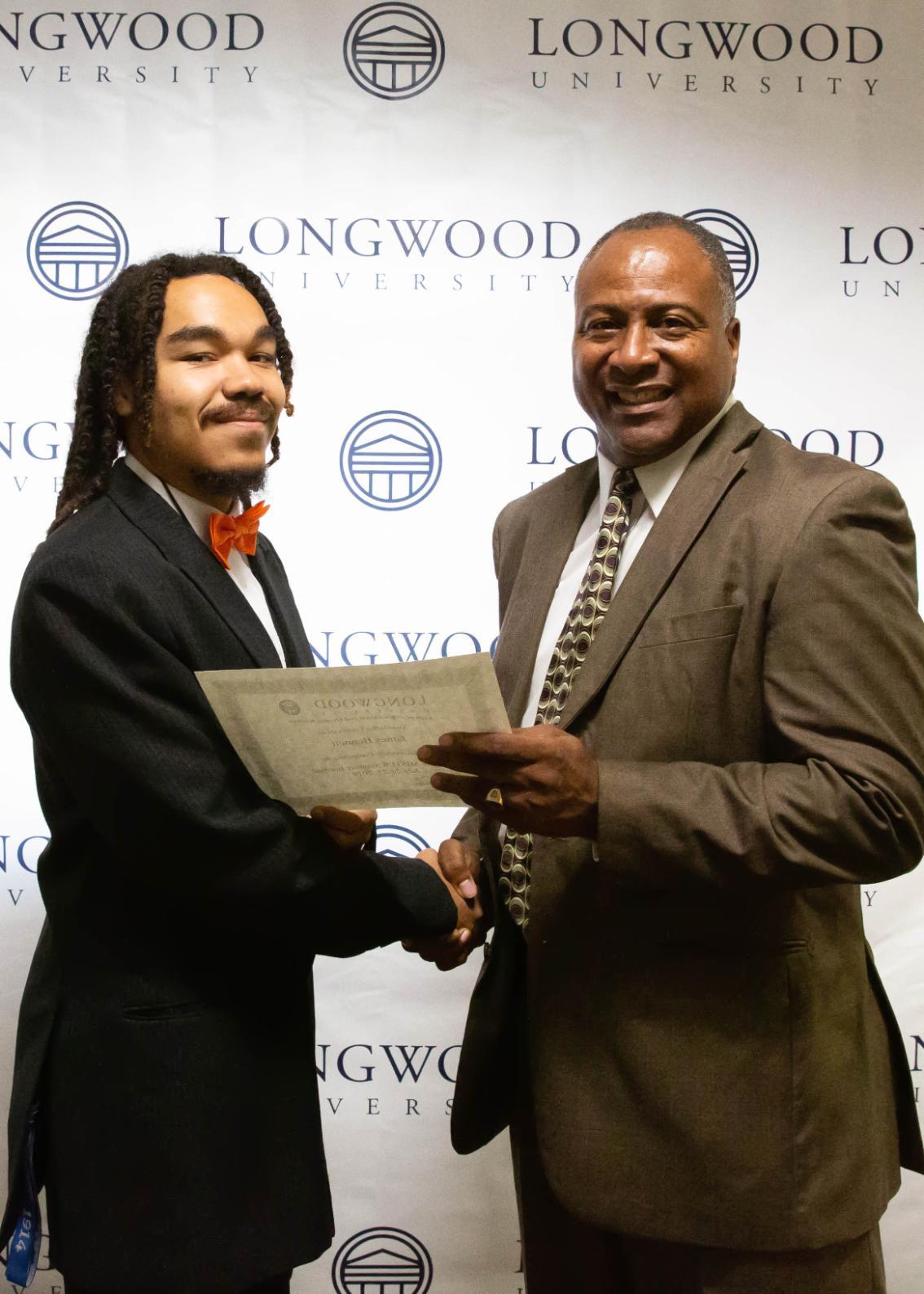 Dr. Maurice Carter makes a presentation to James Bennett during the Call Me MISTER Summer Institute banquet in August. 