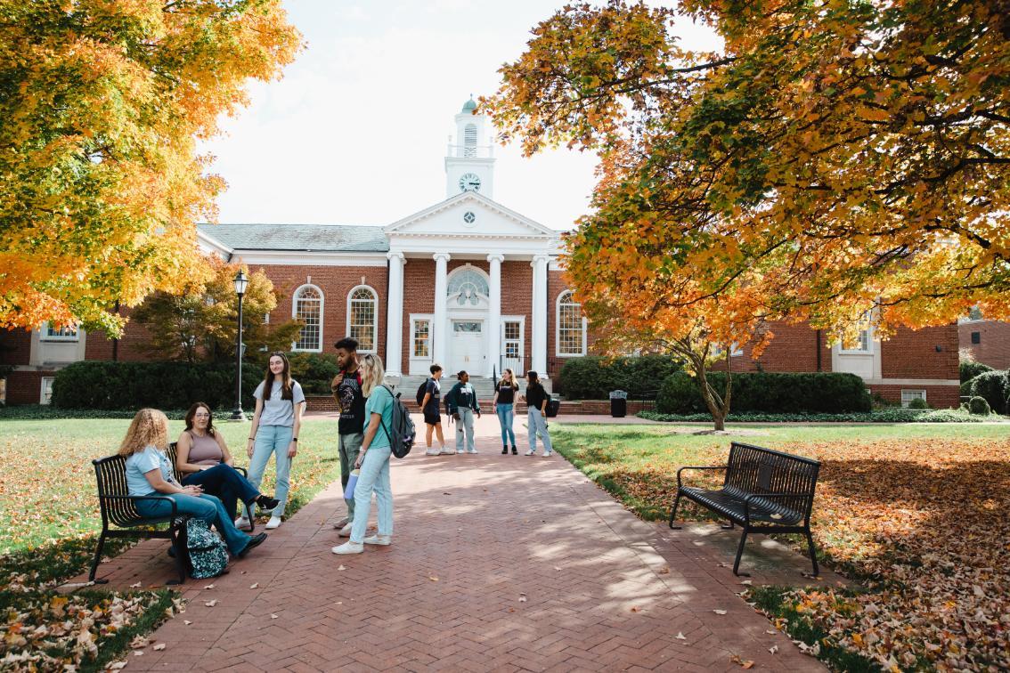 Students sitting and walking outside Eason Hall in the fall